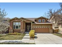 Charming home with a two-car garage, stone accents, and a well-manicured lawn on a sunny day at 10117 Waco St, Commerce City, CO 80022