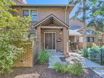 Charming brick townhome featuring a covered entryway and neatly landscaped surroundings at 3540 E 5Th Ave, Denver, CO 80206