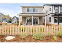 Charming two-story home features a cozy front porch with rocking chairs and a welcoming picket fence at 129 Mesa Way, Superior, CO 80027