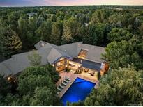 Luxury estate aerial view showcasing private pool, landscaped grounds, and architectural roofline amid lush surroundings at 4766 S Fillmore Ct, Cherry Hills Village, CO 80113