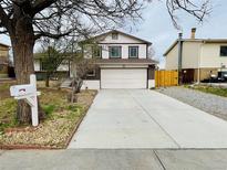 Two-story home with a wide concrete driveway and a white double-door garage at 15155 E Bails Pl, Aurora, CO 80012