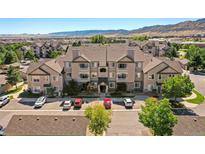 Apartment homes with manicured lawns and mature trees showcasing a well maintained community and mountain views at 9622 W Coco Cir # 203, Littleton, CO 80128