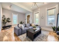 Bright living room features a comfortable gray sectional sofa, stylish lighting, and hardwood floors at 953 Kalamath St, Denver, CO 80204