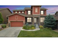 Inviting two-story home with a blend of stone and siding, complemented by a lush front yard at 21962 E Idyllwilde Dr, Parker, CO 80138