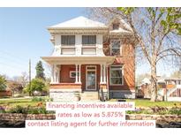 Charming two-story brick home featuring a classic front porch and well-maintained landscaping at 3905 Tejon St, Denver, CO 80211