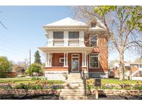 Charming two-story brick home with a covered front porch and well-manicured landscaping at 3905 Tejon St, Denver, CO 80211