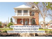 Inviting two-story brick home featuring a classic facade, landscaped front yard, and a welcoming porch with stately columns at 3905 Tejon St, Denver, CO 80211