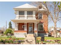 Charming two-story brick home with a covered front porch and colorful landscaping, offering classic curb appeal at 3905 Tejon St, Denver, CO 80211