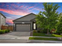 Charming single-Gathering home with a two-car garage, stone accents, a well-kept lawn and a picturesque sunset backdrop at 9628 Albion Ln, Thornton, CO 80229