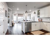 Open concept kitchen with island, stainless steel appliances, and white shaker cabinets at 20 Wilcox St # 403, Castle Rock, CO 80104