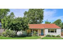 Charming home featuring a red tile roof, blue door, white brick, and a lush green lawn at 225 N Ivanhoe St, Denver, CO 80220