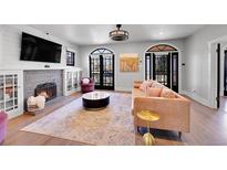 Stylish living room featuring a fireplace, arched windows, hardwood floors, and modern furnishings at 4495 Utica St, Denver, CO 80212