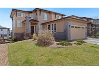 Attractive two-story home featuring a two-car garage, well-manicured lawn and stylish stone accents at 9486 Juniper Way, Arvada, CO 80007