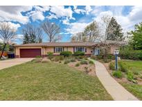 Charming brick ranch-style home with an attached garage, mature landscaping, and inviting walkway at 6544 E Alaska Dr, Denver, CO 80224
