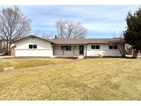 Ranch style home features light colored brick and siding, and a well maintained front yard at 2090 S Clinton St, Denver, CO 80231