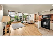Bright living room featuring hardwood floors, large windows, and modern decor at 2351 Federal Blvd # 401, Denver, CO 80211