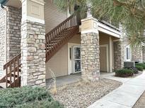 Inviting condo exterior with stone accents, private entrance, and well-maintained landscaping at 4054 S Crystal Cir # 103, Aurora, CO 80014