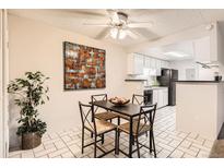 Cozy dining room with a ceiling fan and an adjacent kitchen area with black appliances at 18091 E Kentucky Ave # 202, Aurora, CO 80017