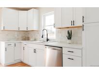 Bright kitchen featuring stainless steel appliances, white cabinets, and modern fixtures at 930 S Lowell Blvd, Denver, CO 80219