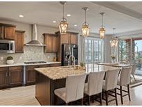 Spacious kitchen with a large center island, granite countertops, and pendant lighting at 11999 S Stroll Ln, Parker, CO 80138