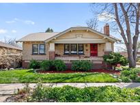 Charming brick home featuring a well-manicured front lawn and inviting red door at 3242 Utica St, Denver, CO 80212