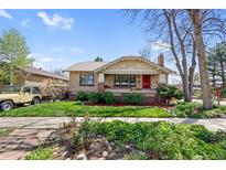 Charming brick home with a well-maintained lawn, a red door, and lush landscaping at 3242 Utica St, Denver, CO 80212