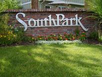 Welcoming Southpark community sign with brick wall, colorful flowers, and lush green lawn at 2980 W Long Dr # E, Littleton, CO 80120