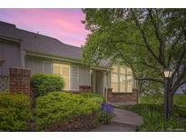 Charming home featuring mature landscaping, brick accents, and a welcoming walkway to the front door at 2980 W Long Dr # E, Littleton, CO 80120