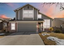 Charming two-story home boasts a two-car garage, brick accents, and a well-manicured front yard at 13755 W Amherst Way, Lakewood, CO 80228