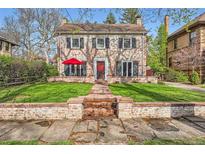 Charming two-story brick home with well-maintained lawn and a red front door at 2060 Ash St, Denver, CO 80207