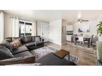 Open concept living room featuring a cozy sectional sofa and a dining area with modern decor at 7937 Chase Cir # 176, Arvada, CO 80003