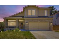 Charming two-story home with a well-manicured lawn and a welcoming front porch and two-car garage at 5130 Morning Glory Pl, Highlands Ranch, CO 80130