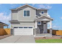 Charming two-story home with a two-car garage and stone accent, offering a blend of modern design and classic appeal at 17945 E 94Th Ave, Commerce City, CO 80022