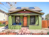 Charming home featuring a vibrant green facade, skylights, and a cozy front porch with colorful Adirondack chairs at 3521 W 40Th Ave, Denver, CO 80211