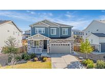 Beautiful two-story home featuring stone accents, a covered porch, and a two-car garage at 118 N Newcastle Way, Aurora, CO 80018