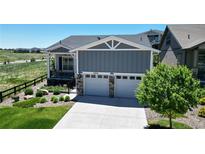 Charming home featuring a two-car garage, covered porch, and attractive landscaping at 22674 E Henderson Dr, Aurora, CO 80016