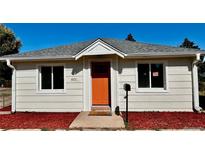 Charming home exterior featuring a bright orange front door and manicured landscaping at 601 W Layton Ave, Englewood, CO 80110