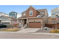 Inviting two-story home featuring a well-manicured lawn, two-car garage, and charming front porch at 1262 High Point Trl, Elizabeth, CO 80107