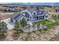 Beautiful home with an immaculate yard, covered patio with outdoor furniture, and a three car garage at 2690 Fox View Trl, Franktown, CO 80116