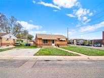 Charming brick home with a well-maintained lawn and a long driveway in a quiet neighborhood at 6800 Fern Dr, Denver, CO 80221