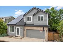 Charming two-story home featuring a grey exterior, solar panels, and a basketball hoop on the driveway at 1551 Northridge Dr, Highlands Ranch, CO 80126