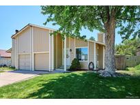 Charming two-story home with attached garage and well-manicured lawn under a clear blue sky at 15440 E Oberlin Pl, Aurora, CO 80013