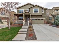 Inviting two-story home featuring a well-manicured lawn, concrete driveway, and a welcoming front porch at 697 Sundance Cir, Erie, CO 80516