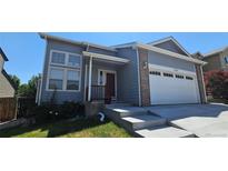 Charming home with gray siding, brick accents, attached garage, and well-maintained front yard at 12388 Jasmine St, Brighton, CO 80602