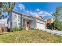 Charming two-story home with blue siding, well-manicured front yard, and two-car garage at 12388 Jasmine St, Brighton, CO 80602