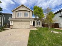 Charming two-story home with a manicured lawn and an attached two-car garage at 5521 Spruce Ave, Castle Rock, CO 80104