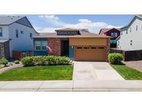 Inviting single-story home featuring a manicured lawn, brick accents, and a two-car garage at 6932 E 133Rd Ave, Thornton, CO 80602