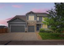 Charming two-story home with stone accents, three-car garage, and well-manicured lawn at 8522 S Dudley St, Littleton, CO 80128