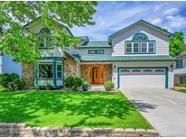 Charming two-story home featuring stone accents, well-manicured lawn and lush landscaping at 379 Lincoln Ct, Louisville, CO 80027