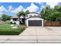 Charming two-story home featuring a two-car garage, manicured lawn, and inviting front porch at 8249 Zephyr St, Arvada, CO 80005